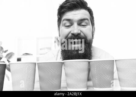 Alternative concept. Pick one. Diversity and recycling. Eco paper cup. Coffee to go paper cup. How many cups per day. Choose from alternatives. Man bearded choosing one of lot colorful paper cups. Stock Photo