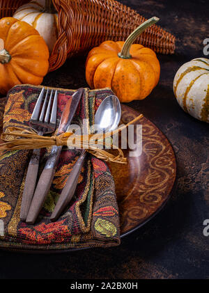 Autumn place setting and mini pumpkins on a rustic wooden table Stock Photo