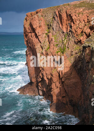 Sea cliffs near North Ham on Muckle Roe, Shetland, UK - the rock is of the Muckle Roe Intrusion - granite, granophyric - igneous bedrock. Stock Photo