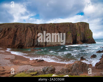 Sea cliffs near North Ham on Muckle Roe, Shetland, UK - the rock is of the Muckle Roe Intrusion - granite, granophyric - igneous bedrock. Stock Photo