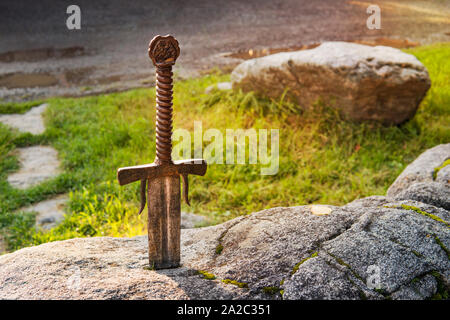 Excalibur, King Arthur's sword in the stone. Edged weapons from the legend Pro king Arthur. Stock Photo