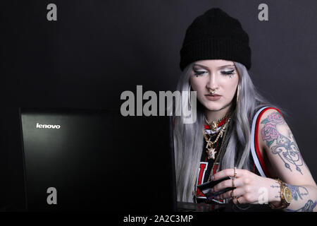 Millennial woman on laptop using credit card for online shopping or fraud, low key 2019 modern cyber security hacking Stock Photo