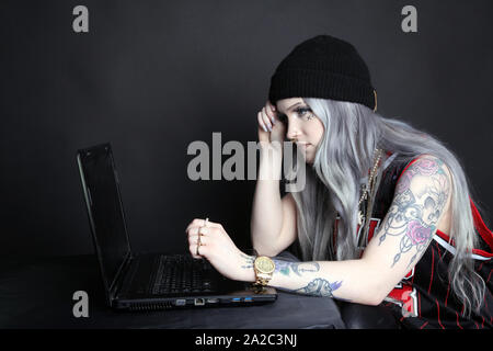 Side view of millennial woman on laptop looking at blank screen, low key 2019 Stock Photo