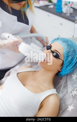 Portrait of female cosmetologist with young woman client in bathrobe sitting in the cosmetologist office Stock Photo