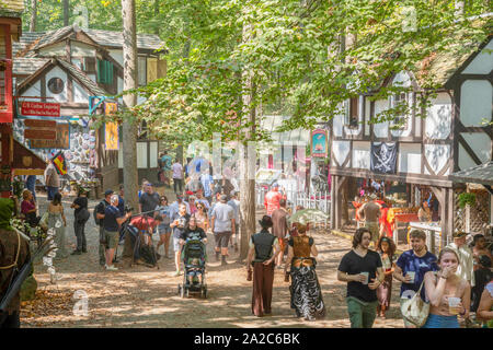 Visitors, some in costume, enjoy the bucolic setting at the annual Maryland Renaissance Festival in Crownsville, MD. Stock Photo