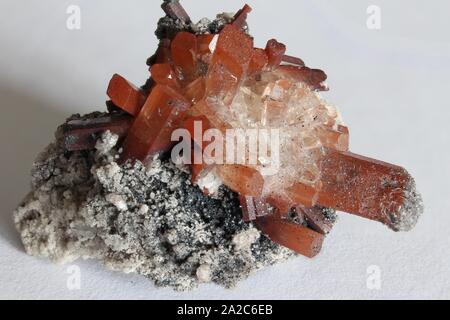 Rock matrix with small crystals and orange and clear topaz with white background Stock Photo