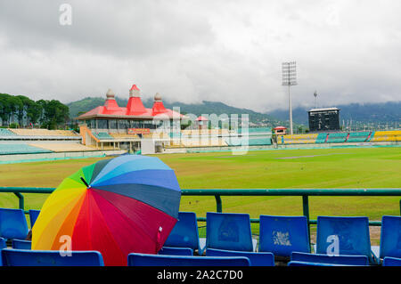 colorful umbrella on the seats of Dharamshala himachal cricket stadium Stock Photo