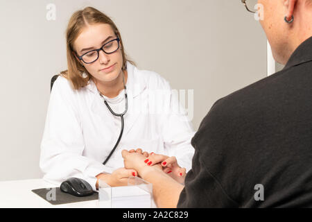 doctor manually measures the pulse on a patient's wrist Stock Photo