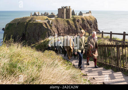The Prince of Wales, known as the Duke of Rothesay while in Scotland, is accompanied by castle owner George Pearson (front left), during a visit to Dunnottar Castle, the cliff top fortress which was once the home of the Earls Marischal, near Stonehaven. Stock Photo