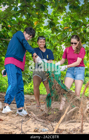 People of different nationalities cleaning garbage on the black beach to clean the beach in the world environment, volunteer concept Stock Photo