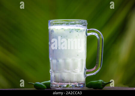 Butter Milk on glass with green chilli isolated. Stock Photo