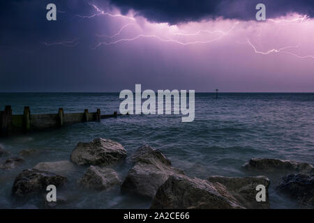 A lightning storm over the English Channel at night viewed from the beach at Selsey, West Sussex, England. Stock Photo