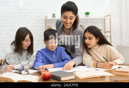 Education concept. Happy teacher helping children doing test Stock Photo