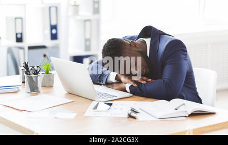 Tired black businessman sleeping in his office Stock Photo