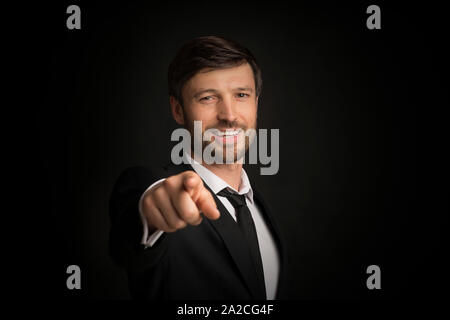 Businessman Pointing Finger Smiling At Camera, Studio Shot Stock Photo