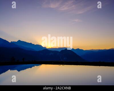 Alpine panorama, mountain silhouettes reflected in an artificial mountain lake at sunset, Hochkalter, Reiteralpe, Berchtesgadener Alps, National Park Stock Photo
