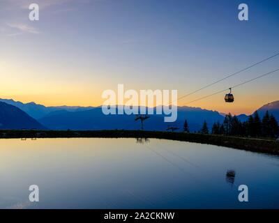 Alpine panorama, gondola of the Jennerbahn cable car reflected in the evening light in an artificial mountain lake, Jenner, Berchtesgadener Alps Stock Photo
