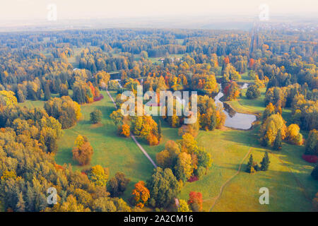 Aerial view flight over autumn valley park with meadows and a winding river, ponds, bright trees Stock Photo