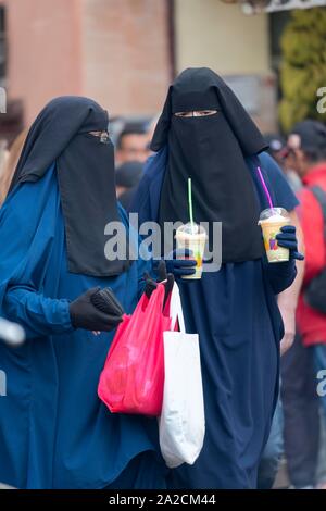 Veiled women on a shopping spree, Souk, Medina, Marrakech, Morocco Stock Photo