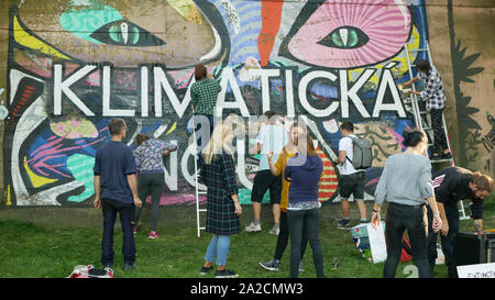 Activists people paints and repainting symbol Extinction Rebellion on legal wall for graffiti, action demonstration against climate change, people eco Stock Photo