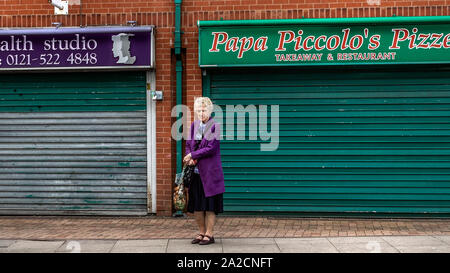 Elderly women standing in front of closed down shops, Tipton in the borough of Sandwell, West Midlands. Stock Photo