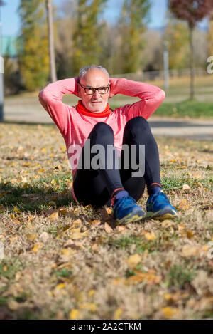 Senior Man Exercising In Park Stock Photo