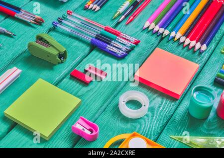 Creative school concept. Arranged school accessories on a green desk. Stock Photo