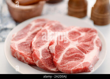 Close up of raw fresh pork neck meat steaks on the plate Stock Photo