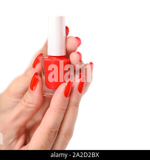 Hands of a woman with red manicure and nail polish bottle on white background Stock Photo