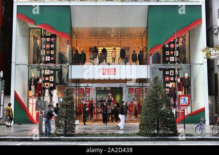 TOKYO, JAPAN - DECEMBER 1, 2016: People walk by Uniqlo fashion store in Ginza district of Tokyo, Japan. Ginza is a legendary shopping area in Chuo War Stock Photo