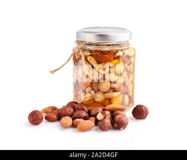 Healthy mix of natural honey with different nuts in a jar on white