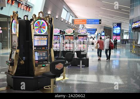 LAS VEGAS, USA - APRIL 15, 2014: Passengers walk by slot machines at Las Vegas McCarran International Airportt in USA. It was the 24th busiest airport Stock Photo