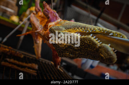 Close up of grilled whole crocodile at a food stall in the market in Bangkok, Thailand Stock Photo