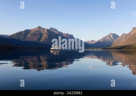 Glacier National Park, Montana, United States of America - September 1, 2019: Boat cruising in Lake McDonald with American Rocky Mountains in the back Stock Photo