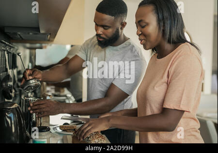 Smiling young African American couple making breakfast together Stock Photo