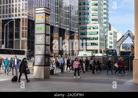 Commuters at rush hour past by post with the transit operators out of Union Station on a sunny afternoon. Stock Photo