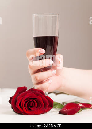Beautiful woman hand with polished nais holding glass of red wine Stock Photo