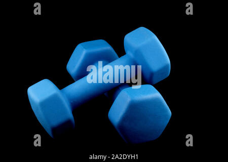 Blue dumbells isolated on a black background Stock Photo