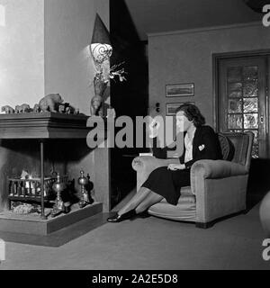 Die schwedische Schauspielerin und Sängerin Zarah Leander am Kamin in ihrem Haus in Berlin, Deutschland 1930er Jahre. Swedish singer and actress Zarah Leander at the fireplace in her house at Berlin, Germany 1930s. Stock Photo