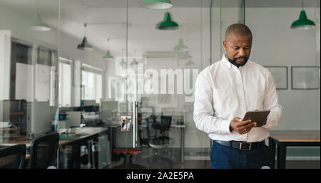 Mature African American businessman using a tablet in an office Stock Photo
