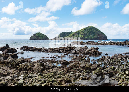 View of the Islet of Vila Franca do Campo from a volcanic lava rock beach on the southern coast of São Miguel Island in the Azores. Stock Photo