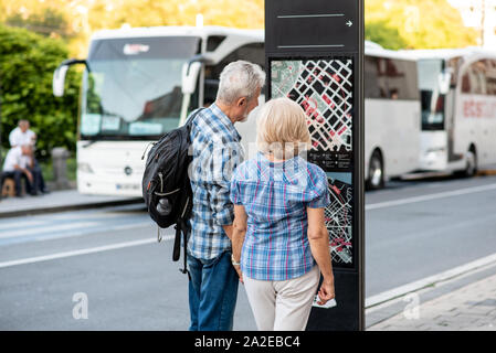 Senior couple of tourists on vacation looking at city map Stock Photo