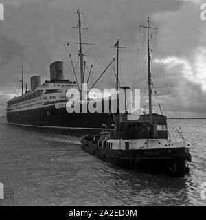 Der Schlepper 'Vulkan' zieht das Passagierschiff 'Europa' in den Hafen von Bremerhaven, Deutschland, 1930er Jahre. Tug boat 'Vulkan' pulling passenger ship 'Europa' into the harbor Bremerhaven, Germany 1930s. Stock Photo