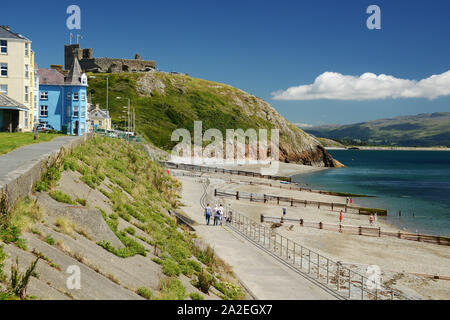 Looking along the promenade towards Criccieth Castle high on the hill dominating views in North Wales Stock Photo