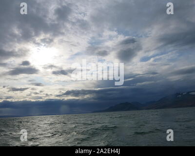 Icelandic scenery of choppy waves and distant mountains with glimpses of ice, Skjalfandi Bay Stock Photo
