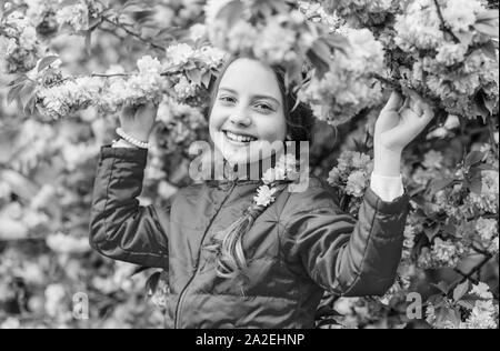 Pink is my favorite. Little girl enjoy spring. Kid on pink flowers of sakura tree background. Kid enjoying pink cherry blossom. Tender bloom. Pink is the most girlish color. Bright and vibrant. Stock Photo