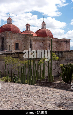 Walls of Zapotec archeological site and the domes of Saint Peter's church. Mitla, Oaxaca, Mexico Stock Photo