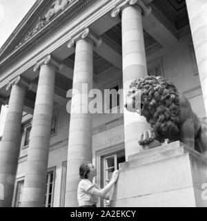 Eine Frau vor der Löwenstatue am Eingang von Schloss Rosenstein in Bad Cannstatt bei Stuttgart, Deutschland 1930er Jahre. A woman in front of a lion sculpture at the entrance of Rosenstein castle at Bad Cannstatt near Stuttgart, Germany 1930s. Stock Photo