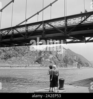 Zwei Jungen winken zwei Frauen von einer Brücke über die Donau bei Passau zu, Deutschland 1930er Jahre. Two boys cheering to two young women from a bridge over river Danube at Passau, Germany 1930s. Stock Photo