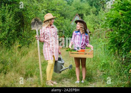 Beautiful female florists. earth day. summer family farm. small girls farmer in village. farming and agriculture. spring country side. children hold gardening tools. ecology and nature protection. Stock Photo